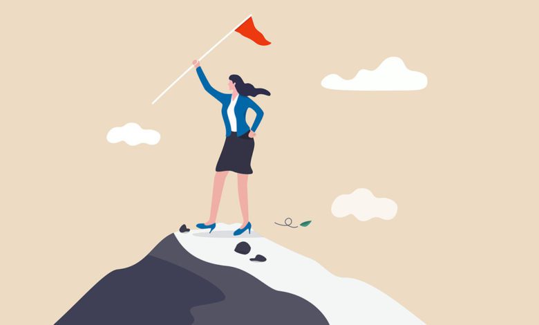 Women on mountain with victory flag